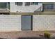 Modern gray wood gate set in a white brick wall offers privacy and enhances curb appeal of the property at 1717 E Morten Ave # 16, Phoenix, AZ 85020