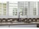 Close up of the kitchen sink with white cabinets, stainless steel faucet, and geometric backsplash at 1717 E Morten Ave # 16, Phoenix, AZ 85020