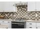 Close up of the kitchen stove with white cabinets and geometric backsplash at 1717 E Morten Ave # 16, Phoenix, AZ 85020