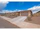 View of single-story home with a two-car garage, set amongst other similar homes at 17310 W Seldon Ln, Waddell, AZ 85355