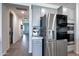 Modern kitchen with stainless steel refrigerator, built-in ovens, and adjacent hallway at 17310 W Seldon Ln, Waddell, AZ 85355