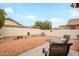 Spacious backyard featuring mature landscaping, a cozy seating area, and a well-maintained perimeter wall at 18080 W Udall Dr, Surprise, AZ 85374