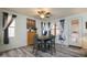 Bright and airy dining area with wood-look floors, decorator window treatments, and modern lighting at 18080 W Udall Dr, Surprise, AZ 85374