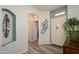 Inviting foyer features arched doorway, art niche, wood-look floors, and neutral-colored walls at 18080 W Udall Dr, Surprise, AZ 85374