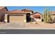 Charming single-Gathering home features a two-car garage, red tile roof, and xeriscaped front yard with desert landscaping at 18080 W Udall Dr, Surprise, AZ 85374