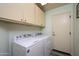 Bright laundry room features a Whirlpool washer and dryer with ample cabinet space at 18080 W Udall Dr, Surprise, AZ 85374