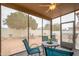 Relaxing sunroom with a ceiling fan offering a serene view of the landscaped backyard and citrus trees at 18080 W Udall Dr, Surprise, AZ 85374
