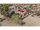 Aerial view showcasing a backyard patio with firepit and red-tiled roof with solar panels in a desert community at 18400 N Deer Grass Ct, Surprise, AZ 85374