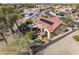 Aerial shot displays a desert home's red-tiled roof with solar panels, backyard patio, desert rock, and landscaping at 18400 N Deer Grass Ct, Surprise, AZ 85374