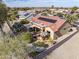 The aerial view shows a desert home with red tile roof and solar panels, a covered patio, and desert landscaping at 18400 N Deer Grass Ct, Surprise, AZ 85374