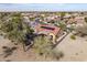 An aerial view displays a red tiled roof with solar panels, a backyard patio, and desert landscaping at 18400 N Deer Grass Ct, Surprise, AZ 85374