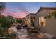 Beautiful backyard patio with lounge seating, dining area, and landscaped garden at sunset at 18400 N Deer Grass Ct, Surprise, AZ 85374