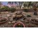 Backyard with desert landscaping, rock waterfall, and potted flower arrangements at 18400 N Deer Grass Ct, Surprise, AZ 85374