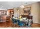 Elegant dining room with hardwood floors, designer table setting, and adjacent kitchen area at 18400 N Deer Grass Ct, Surprise, AZ 85374