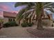 Charming single-story home with mature landscaping, green bushes and palm tree at 18400 N Deer Grass Ct, Surprise, AZ 85374