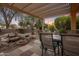 Outdoor patio with a pergola, a dining table set, and lush desert landscaping at 18400 N Deer Grass Ct, Surprise, AZ 85374