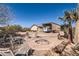 Backyard oasis featuring a stone fire pit, covered parking, desert landscaping, and seating area at 20006 W Highland Ave, Litchfield Park, AZ 85340