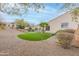 Lush backyard featuring a putting green, palm tree, playhouse, and gravel landscaping at 20618 W Western Dr, Buckeye, AZ 85396