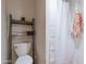 Cozy bathroom featuring a toilet, shelving unit, and shower with a curtain at 20618 W Western Dr, Buckeye, AZ 85396