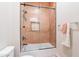 Bathroom featuring a tub with glass enclosure, black matte fixtures, and decorative tile work at 20618 W Western Dr, Buckeye, AZ 85396