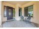 Covered entryway with comfortable seating, decorative planters, and stylish tile flooring at 20618 W Western Dr, Buckeye, AZ 85396