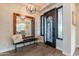 Elegant foyer with a statement mirror, chic bench, and decorative lighting fixture at 20618 W Western Dr, Buckeye, AZ 85396