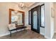 Elegant foyer with a statement mirror, chic bench, and decorative lighting fixture at 20618 W Western Dr, Buckeye, AZ 85396