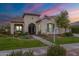 Charming stucco home featuring manicured lawn, beautiful landscaping, and decorative wrought iron accents at 20618 W Western Dr, Buckeye, AZ 85396