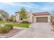 Inviting home featuring an attached garage, tile roof, lush lawn, and mature landscaping at 20618 W Western Dr, Buckeye, AZ 85396