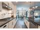 Modern kitchen featuring white cabinetry, tile backsplash, stainless steel appliances, and an eat-in dining area at 20618 W Western Dr, Buckeye, AZ 85396