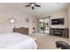 Bright main bedroom featuring sliding doors to the outdoor patio and a large entertainment center at 20618 W Western Dr, Buckeye, AZ 85396