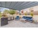 Covered outdoor living space with built in grill, comfortable seating and manicured yard at 20618 W Western Dr, Buckeye, AZ 85396