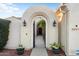 Private arched gate with decorative sconces and potted plants at 22416 N Arrellaga Dr, Sun City West, AZ 85375