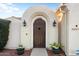Private arched gate with decorative sconces and potted plants at 22416 N Arrellaga Dr, Sun City West, AZ 85375