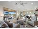 Bright living room features neutral furniture, ceiling fan, and views of the outdoor patio and landscaping at 22416 N Arrellaga Dr, Sun City West, AZ 85375