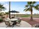 Outdoor patio area with seating, table, and shade umbrella at 22416 N Arrellaga Dr, Sun City West, AZ 85375