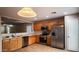 This kitchen features wood cabinets, stainless steel appliances, and an open view to the living area at 22756 W Papago St, Buckeye, AZ 85326