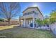 Spacious backyard with lawn, patio, citrus tree, and two-story home with balcony, perfect for outdoor living at 2325 S 88Th Dr, Tolleson, AZ 85353