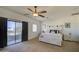 Spacious bedroom with a ceiling fan, closet, a large bed, and a sliding glass door to the patio at 2325 S 88Th Dr, Tolleson, AZ 85353