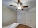 Simple bedroom featuring a ceiling fan, double sliding door closet, and wood-look floors at 2325 S 88Th Dr, Tolleson, AZ 85353