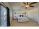 Spacious bedroom with a ceiling fan, a large bed, a sliding glass door to the patio, and a view of the backyard at 2325 S 88Th Dr, Tolleson, AZ 85353