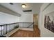 Hallway featuring wood floors, white walls, wood railing and a view of the downstairs at 2325 S 88Th Dr, Tolleson, AZ 85353