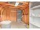 Unfinished basement with exposed wood beams, shelving, and concrete floors at 2365 E Shea Blvd, Phoenix, AZ 85028