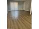 Open living room with wood flooring and a sliding glass door for natural light at 2625 E Indian School Rd # 335, Phoenix, AZ 85016