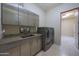 Spacious laundry room with stainless steel appliances, modern cabinetry, and granite countertops at 2718 E Campo Bello Dr, Phoenix, AZ 85032