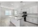 Bright, open kitchen with white cabinets, granite island, stainless steel appliances and tile flooring at 2905 E Aloe Pl, Chandler, AZ 85286