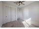 Neutral bedroom with carpet and a ceiling fan, featuring white closet doors for ample storage at 3548 E Tina Dr, Phoenix, AZ 85050