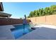 A backyard oasis featuring a swimming pool, rock waterfall, umbrella, and a privacy wall at 3548 E Tina Dr, Phoenix, AZ 85050