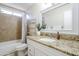 Bright bathroom with granite countertops, vanity, and a shower/tub combo with tiled surround at 3632 W Kelton Ln, Phoenix, AZ 85053