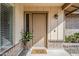Covered entry with a tan door and a decorative plant, with a 'stay awhile' door mat at 3632 W Kelton Ln, Phoenix, AZ 85053